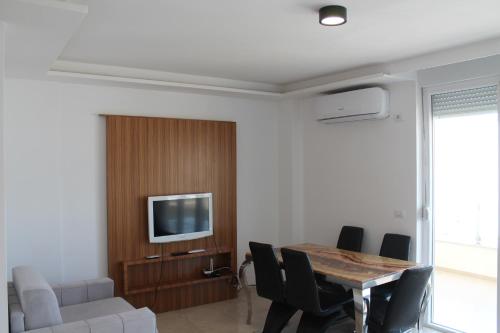 a living room with a table and a tv at Blue Apartments & Hotel Shengjin in Shëngjin