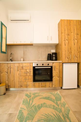a kitchen with wooden cabinets and a white refrigerator at SUITES DREAM TELENDOS in Telendos