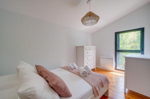 ein Schlafzimmer mit einem Bett mit zwei Handtüchern darauf in der Unterkunft LA VILLA KUDETA - Belle maison avec piscine in Bouliac