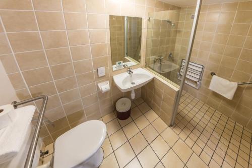 a bathroom with a toilet and a sink and a shower at Road Lodge JNB Airport in Johannesburg