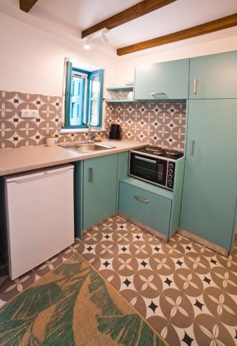 a kitchen with a sink and a stove at SUITES DREAM TELENDOS in Telendos