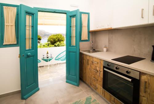 cocina con puertas azules, fregadero y fogones en SUITES DREAM TELENDOS, en Telendos