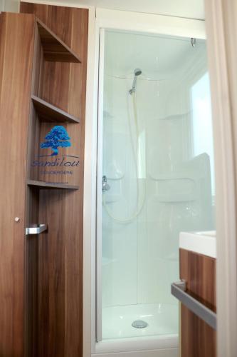 une salle de bain avec douche et porte vitrée dans l'établissement Mobilhome «Aux Portes du Soleil», à Sigean