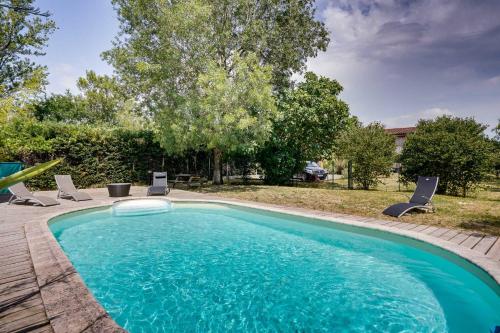 une piscine avec deux chaises longues à côté dans l'établissement La Villa Kudeta - Belle maison avec piscine, à Bouliac