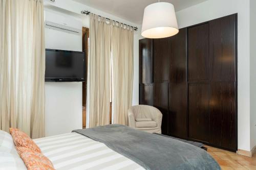 a bedroom with a bed and a chair and a television at B&B Bellini in Milo
