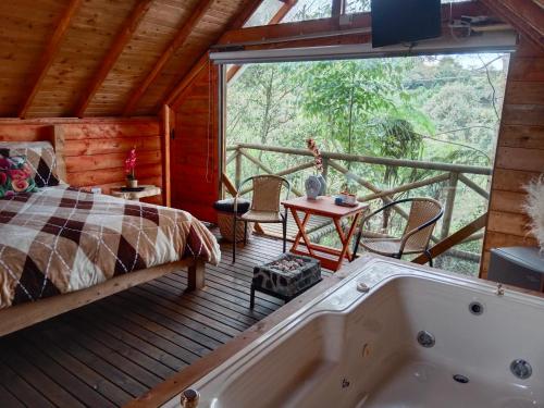 1 dormitorio con cama y bañera en la terraza en Cabaña Arrayanes, en Rionegro
