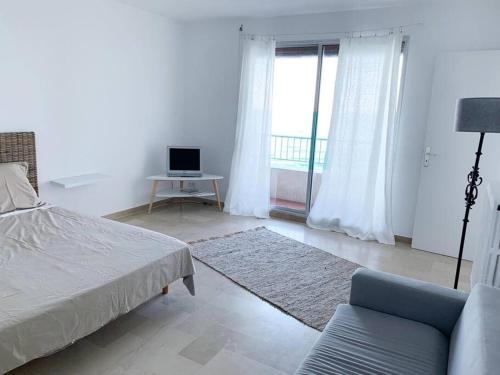 um quarto com uma cama, um sofá e uma janela em Appartement en bord de mer em Pietranera