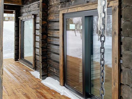 a glass door on the side of a log house at Holiday home Moen in Moen i Målselv