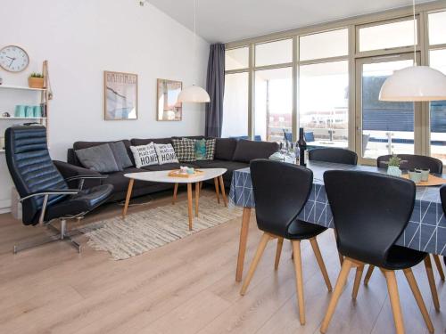 a living room with a couch and a table and chairs at Loft apartment in holiday park, Ringkøbing in Ringkøbing