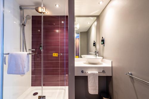 a bathroom with a shower and a sink and a mirror at Premier Inn Essen City Limbecker Platz in Essen