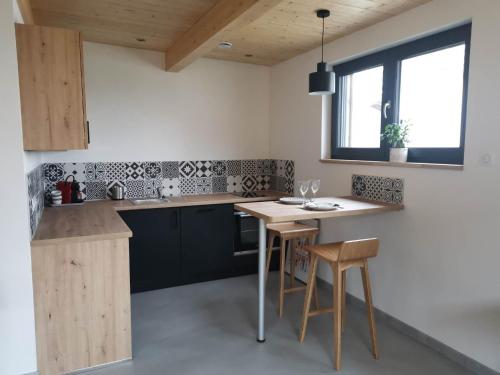 a kitchen with a wooden table and some chairs at Studio cocooning Betschdorf in Oberbetschdorf