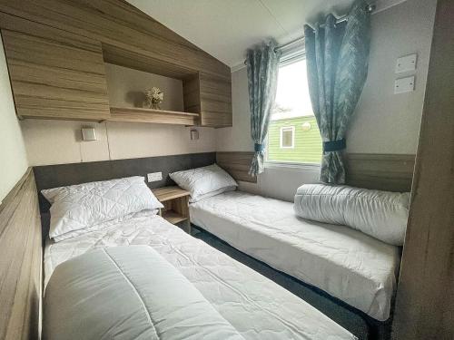 Habitación pequeña con 2 camas y ventana en 6 Berth Caravan With Decking At Sunnydale Holiday Park Ref 35243kg, en Louth