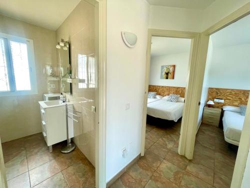 a bathroom with a bed and a sink and a mirror at Mas de la Maria in Cambrils