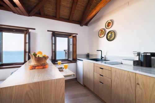una cocina con una barra con un bol de fruta. en Kalnterimi Guesthouses, en Monemvasia