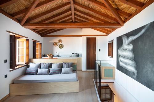 ein Wohnzimmer mit einem Sofa und einer Küche in der Unterkunft Kalnterimi Guesthouses in Monemvasia