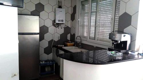 a kitchen with a sink and a refrigerator at la perle de bougie in Bejaïa