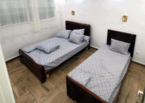 two twin beds in a room with wood floors at la perle de bougie in Bejaïa