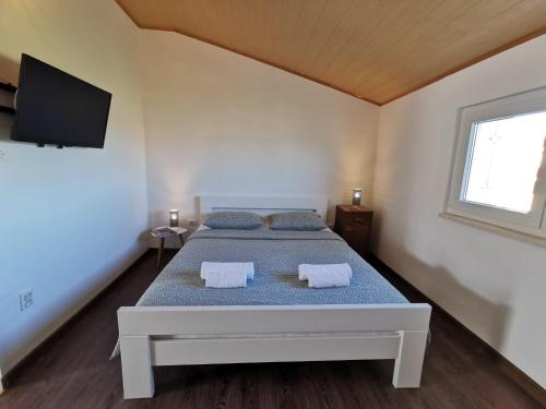 a bedroom with a bed and a tv on the wall at Apartmani Vana 1 in Tribunj