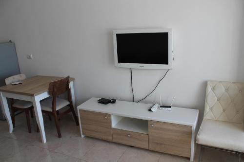 a room with a desk and a tv on a wall at Blue Apartments & Hotel Shengjin in Shëngjin