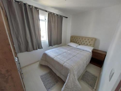 um pequeno quarto com uma cama e uma janela em Apartamento inteiro com garagem coberta em União da Vitória