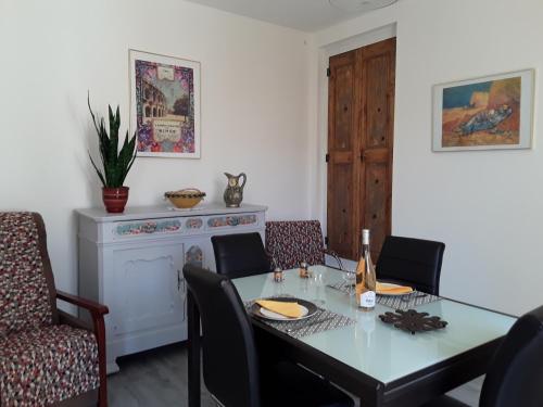 une salle à manger avec une table et une cheminée dans l'établissement L'Oustau, à Beauvoisin