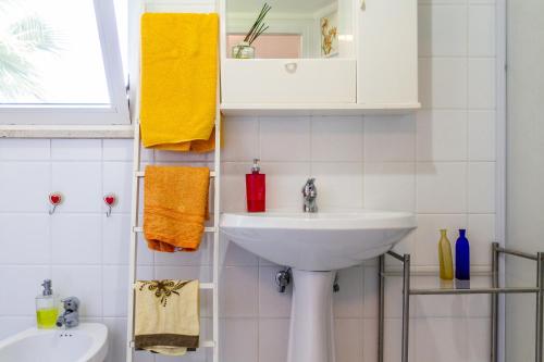 La salle de bains blanche est pourvue d'un lavabo et d'un miroir. dans l'établissement Casina Orbetello, à Orbetello