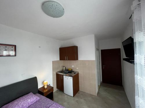 a room with a bed and a small kitchen at Apartmani Sunce in Bar