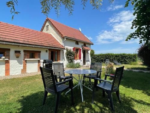 a table and chairs in front of a house at Gîte de la Borde in Fourilles