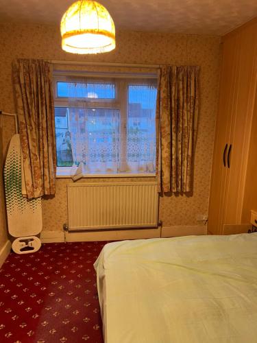 a bedroom with a bed and a window at Whitby road house in Canvey