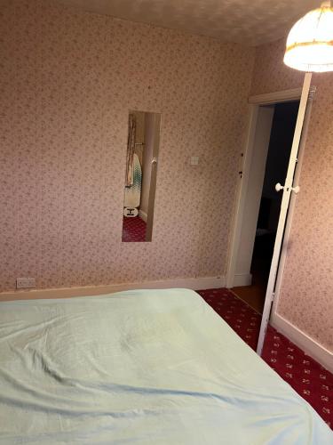 a bedroom with a bed and a mirror on the wall at Whitby road house in Canvey