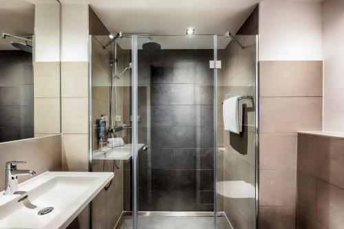 y baño con ducha y lavamanos. en Premier Inn Wiesbaden City Centre, en Wiesbaden