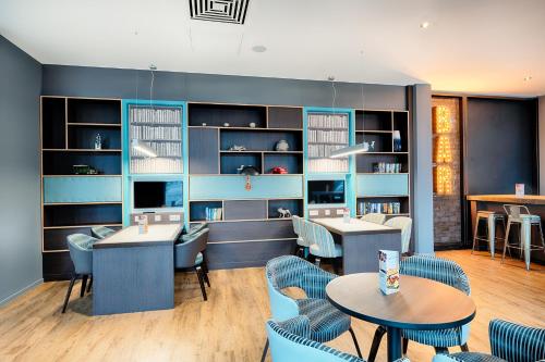a restaurant with blue walls and tables and chairs at Premier Inn Wiesbaden City Centre in Wiesbaden