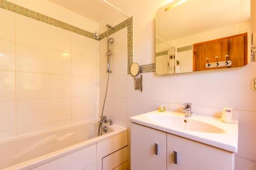La salle de bains est pourvue d'un lavabo, d'une baignoire et d'un miroir. dans l'établissement Le Mas de Riri, à Celles