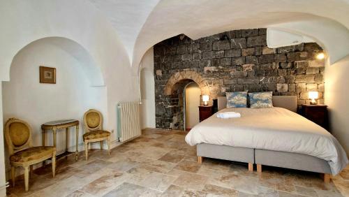 a bedroom with a bed and a stone wall at La tour de Pezene in Anduze