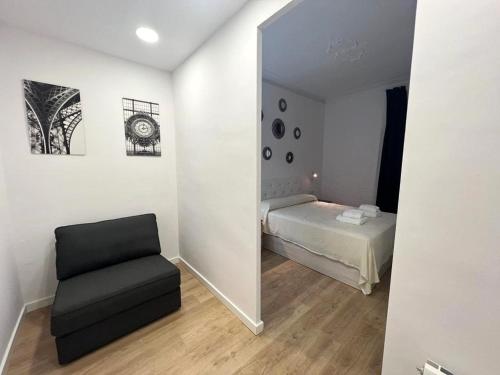 Zimmer mit einem Spiegel, einem Bett und einem Stuhl in der Unterkunft Flor Habitaciones in Barcelona