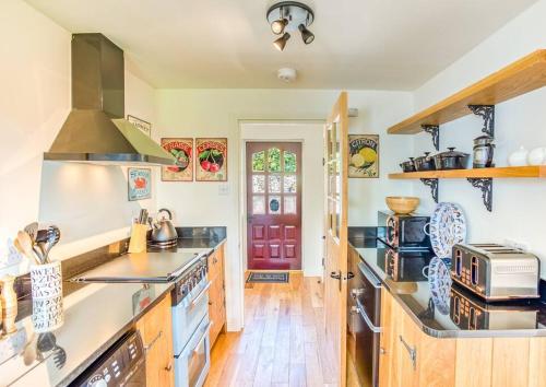a large kitchen with wooden counters and a stove top oven at The Old Barn - cottage with spectacular lake view in Port of Menteith