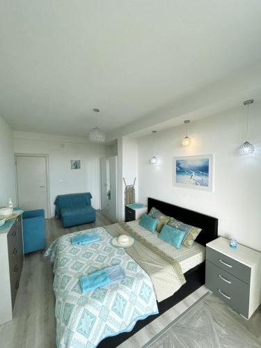 a bedroom with a large bed and a blue chair at Aparthotel Monterria in Bar