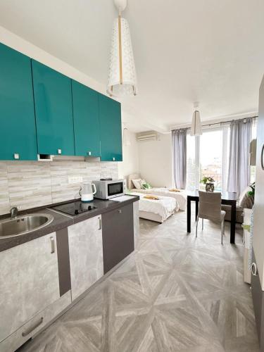 a kitchen with green cabinets and a living room at Aparthotel Monterria in Bar