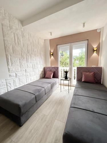 a living room with two beds in front of a stone wall at Aparthotel Monterria in Bar