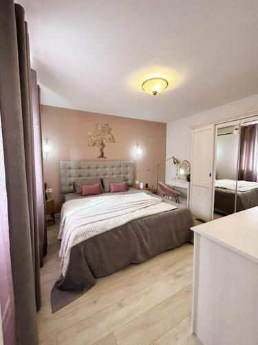 a bedroom with a large bed with pink pillows at Aparthotel Monterria in Bar