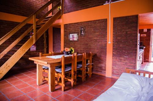 a dining room with a wooden table and stairs at Las Quintas El Bolsón in El Bolsón