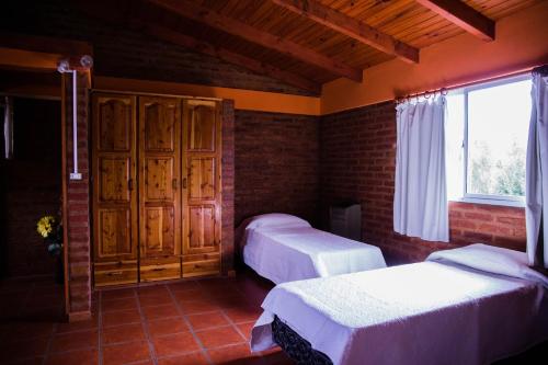 a bedroom with two beds and a window at Las Quintas El Bolsón in El Bolsón
