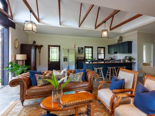 sala de estar con muebles de cuero y cocina en Rivergate Guest Farm, en Stanford