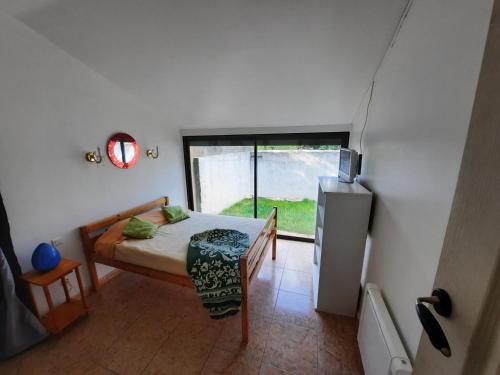 ein kleines Schlafzimmer mit einem Bett und einem Kühlschrank in der Unterkunft Maison de vacances 4 chambres, jardin et toit terrasse in Peyriac-de-Mer