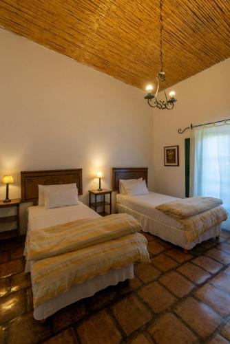 a bedroom with two beds and a chandelier at Hotel El Manantial del Silencio in Purmamarca