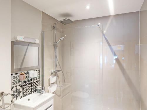a bathroom with a shower and a toilet and a sink at Pebblestone in East Wittering