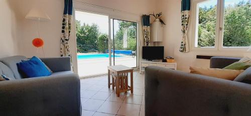 un salon avec deux canapés et une télévision dans l'établissement La petite maison du Bosc, à Saint-Antonin