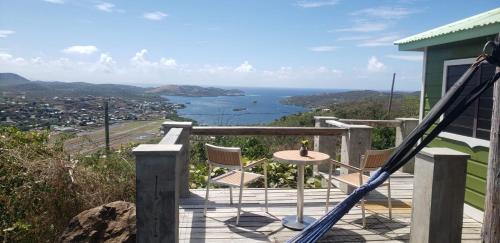 a balcony with a table and chairs and a view of the ocean at Aleli Cottages in Culebra