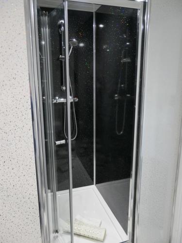 a shower in a bathroom with a glass door at The Cumberland in Llandudno