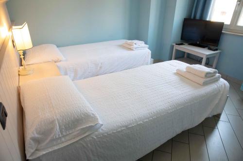 two beds in a small room with a television at Borgo alla Sorgente in Vallio Terme